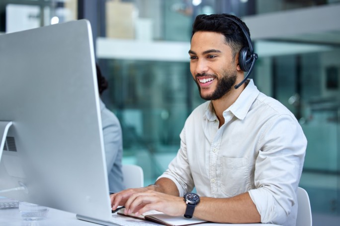 Man at computer with headset